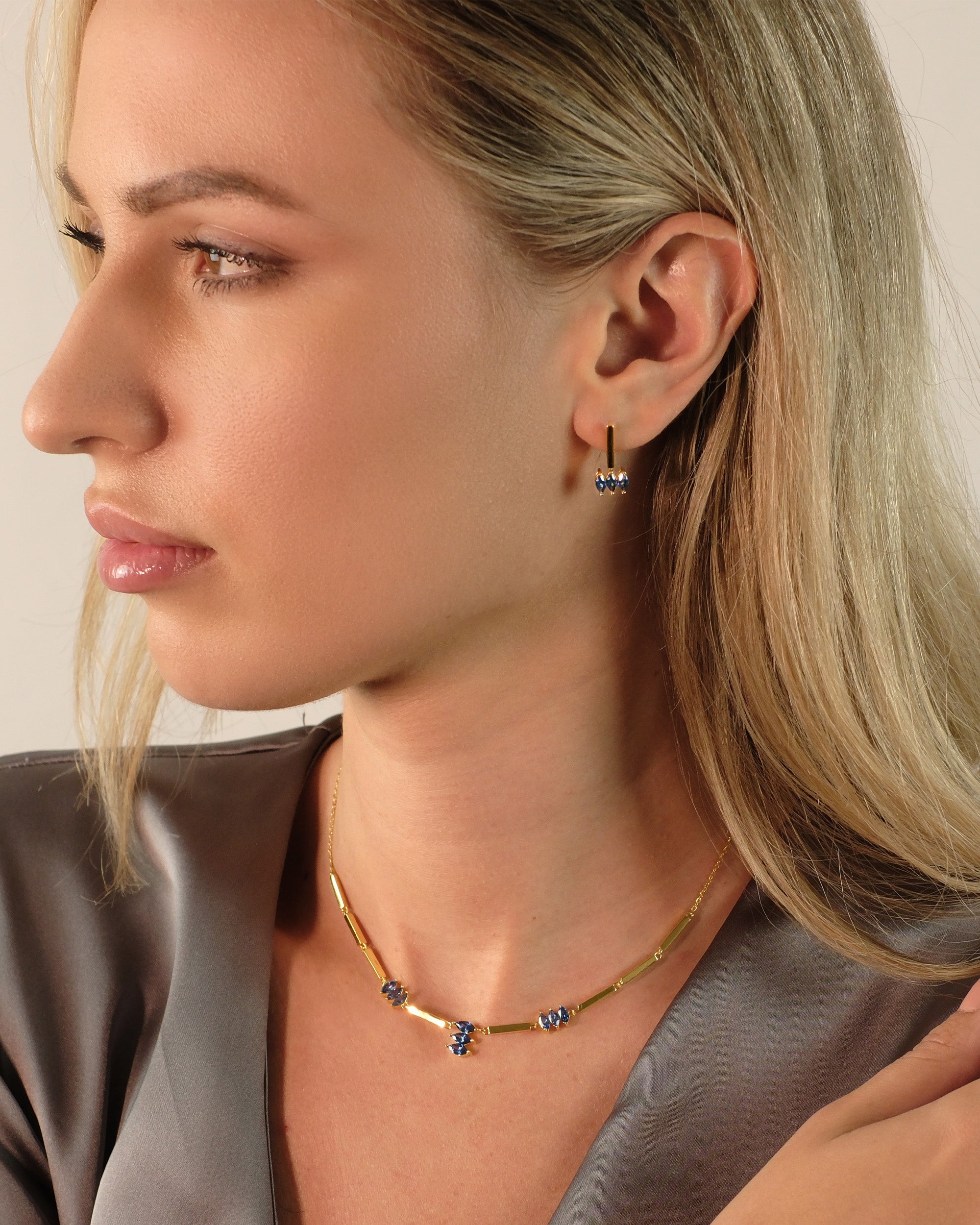 Seitliche Aufnahme: Model trägt Cosytas Moira Blue Ohrringe aus 18k Gold Vermeil auf 925 Silber