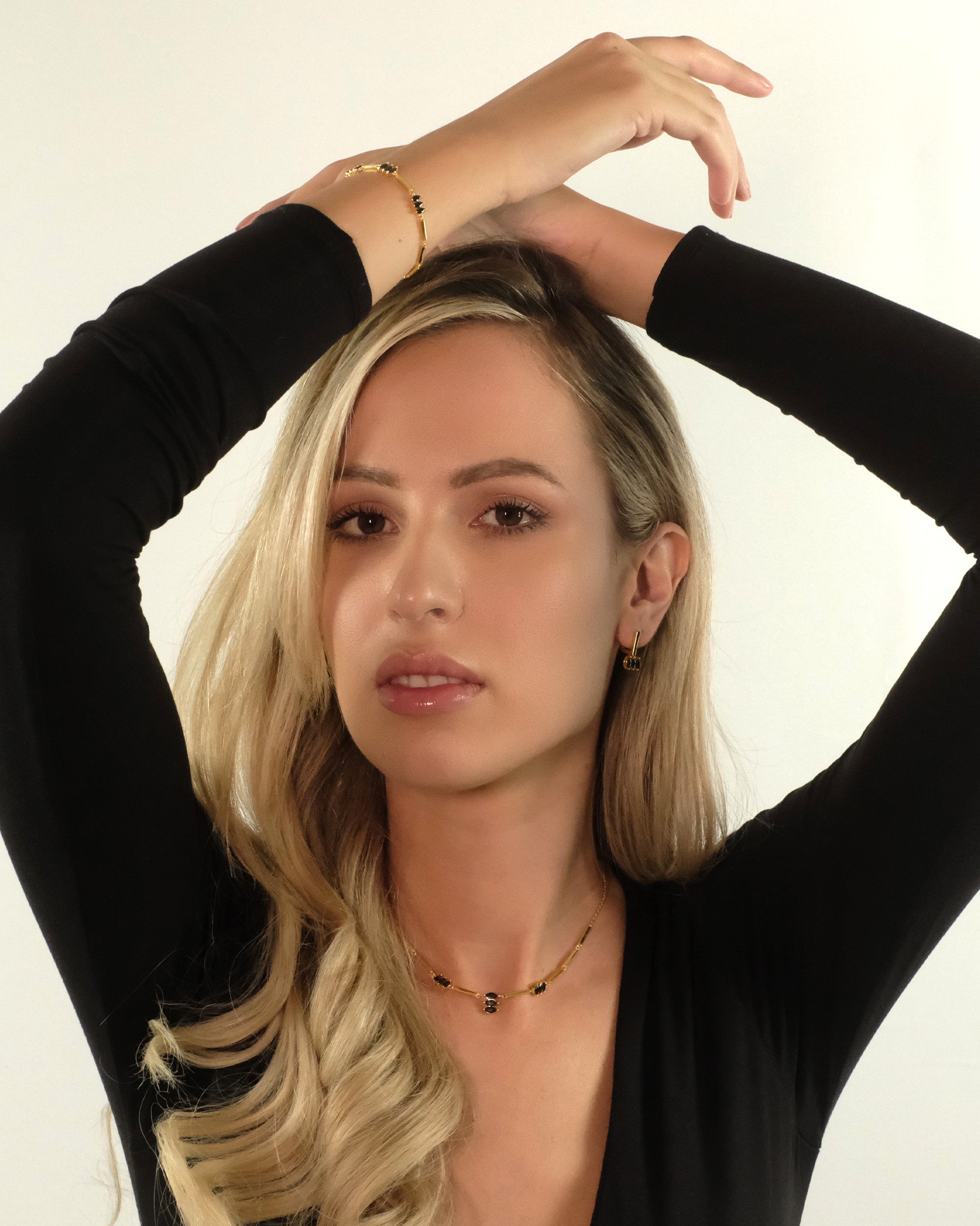 Model mit erhobenen Armen trägt das Moira Black Armband von Cosytas aus 18k Gold Vermeil auf 925 Silber.