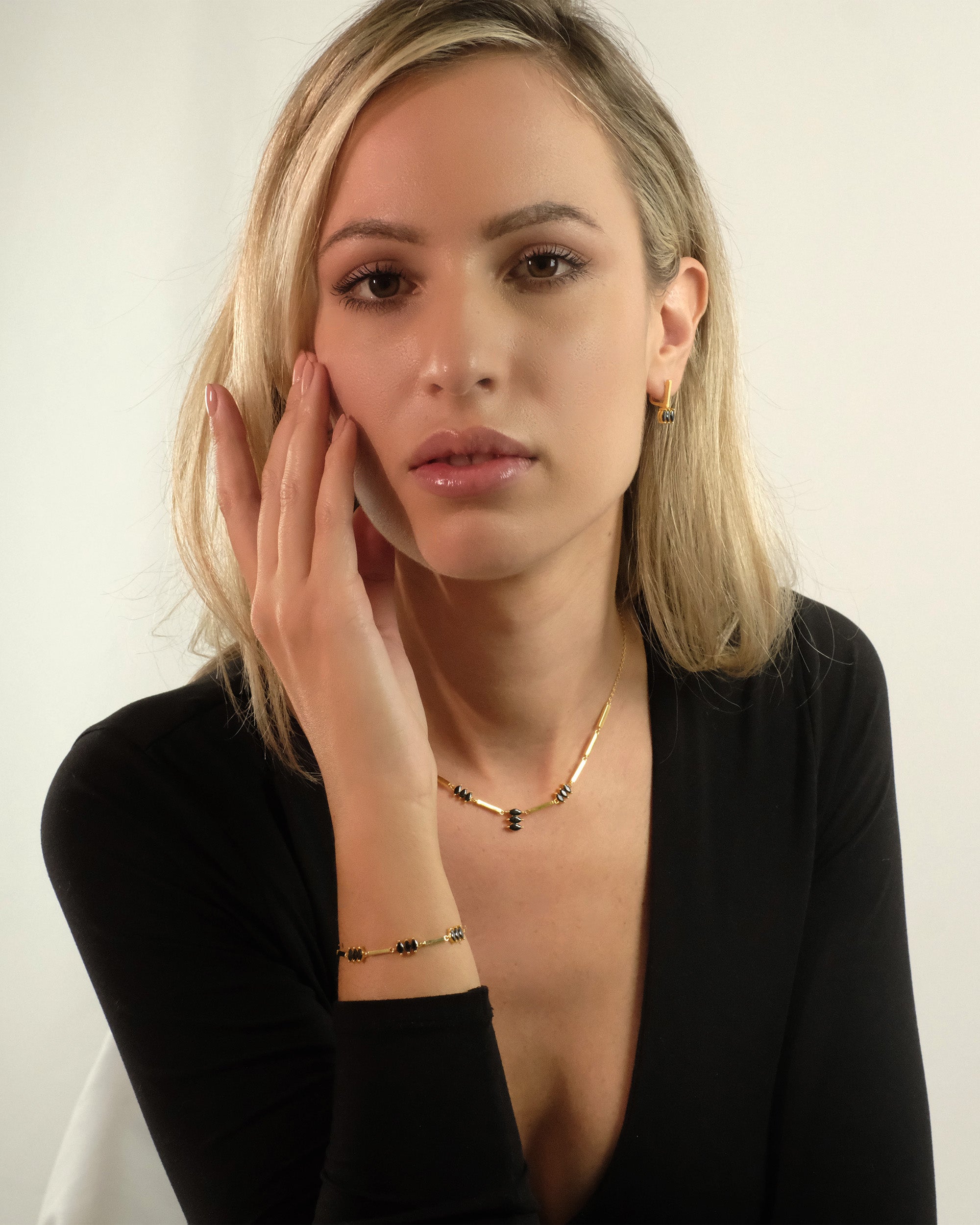 Nahaufnahme des Moira Black Sets von Cosytas aus 18k Gold Vermeil auf 925 Silber, getragen am Handgelenk und Hals.