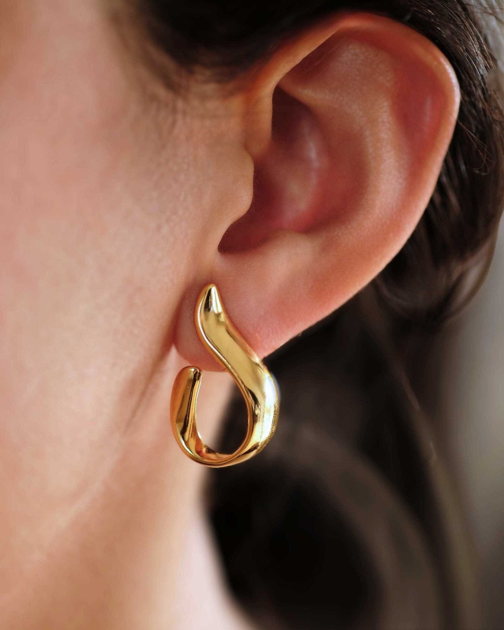 Detailaufnahme einer Frau mit Cosytas Golden Wave Hoops aus 925er Sterling-Silber, 18k-gold-vergoldet
