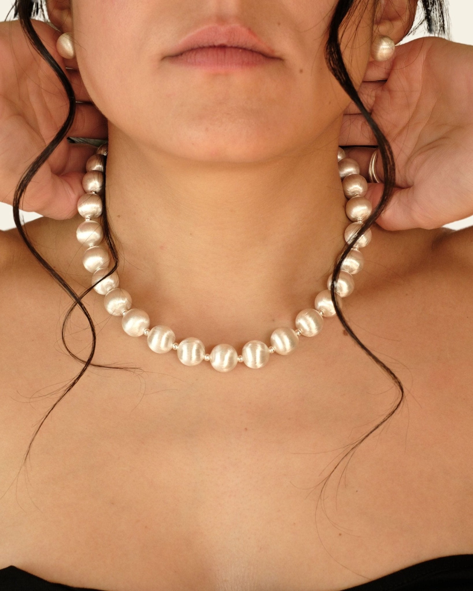 Frau mit Cosytas Lumina Silver Sphere Halskette mit satinierten Silberkugeln