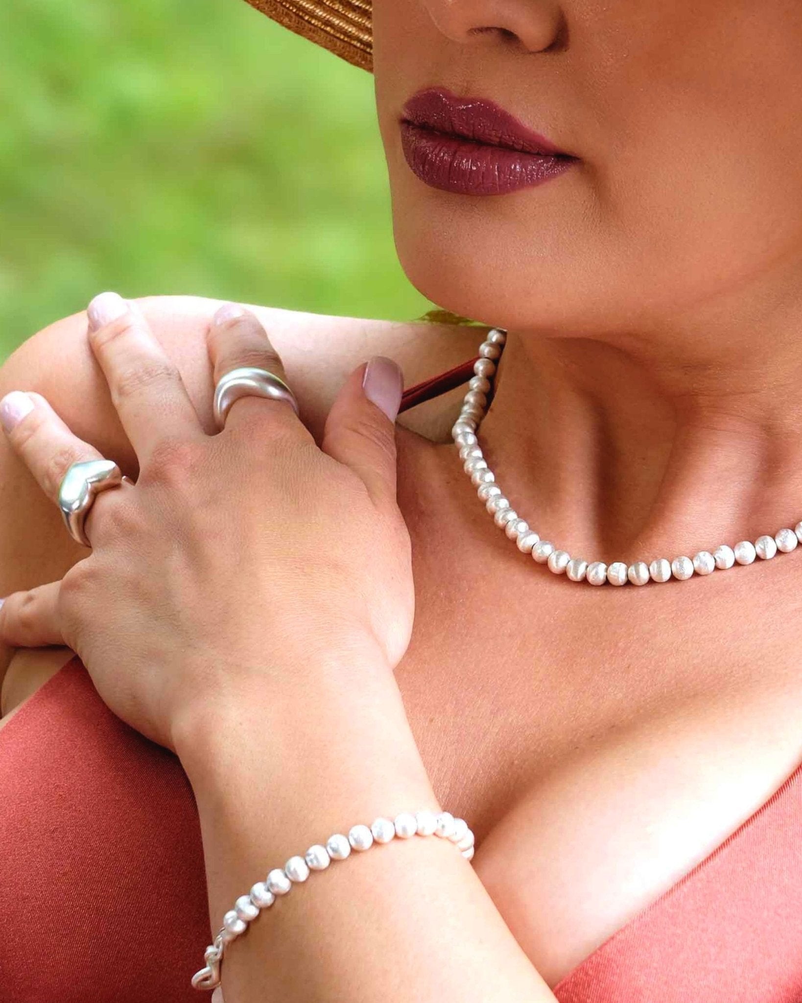 Model mit Lumina Slim Silver Sphere Armband kombiniert mit passender Halskette in elegantem Look.