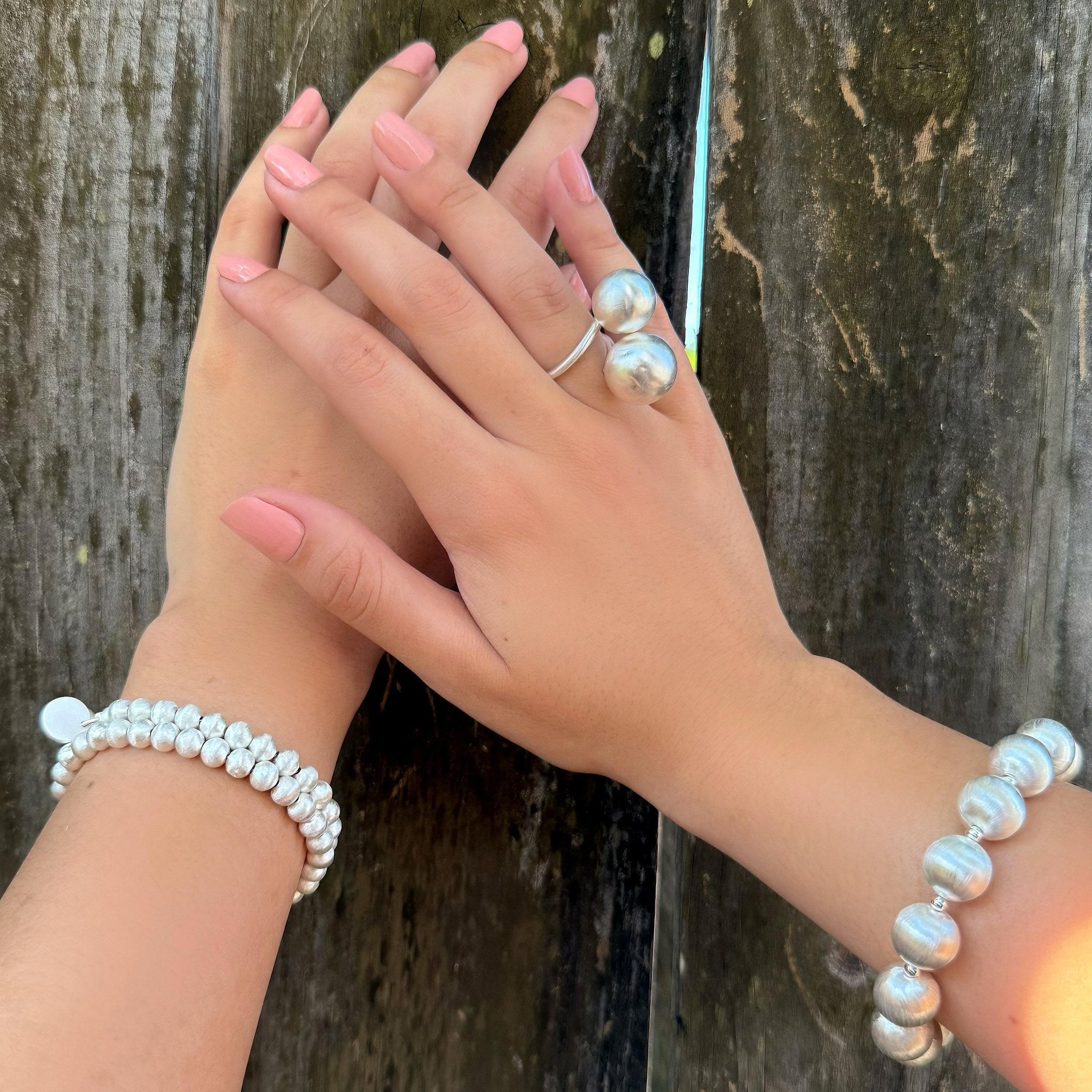 Hand mit
Lumina Slim Silver Sphere Armband von Cosytas