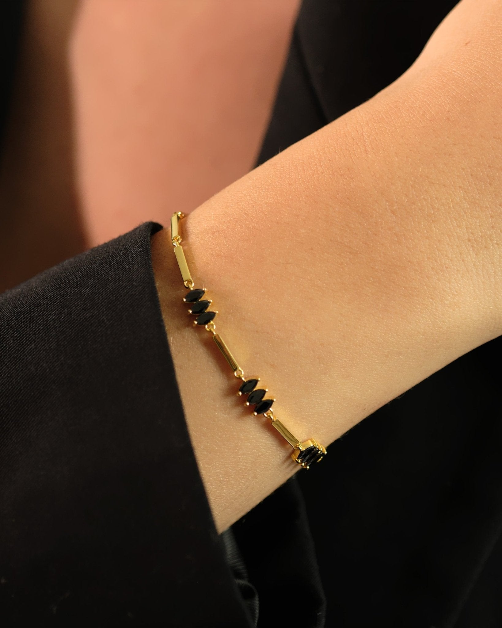 Nahaufnahme des Moira Black Armbands von Cosytas aus 18k Gold Vermeil auf 925 Silber, getragen am Handgelenk.