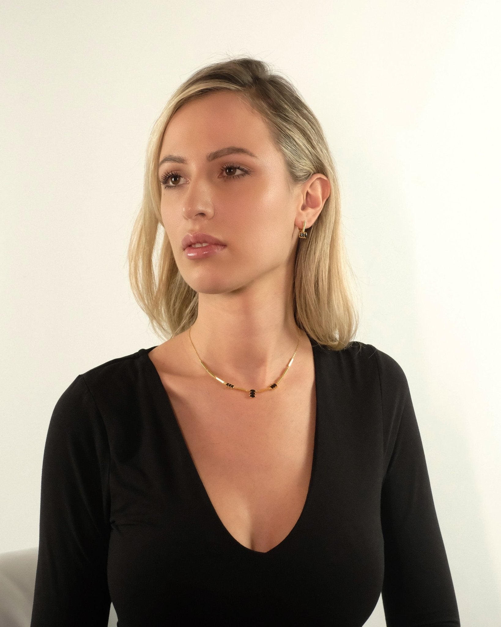 Ein Model trägt die Moira Black Halskette von Cosytas aus 18k Gold Vermeil auf 925 Silber zu einem eleganten Outfit.