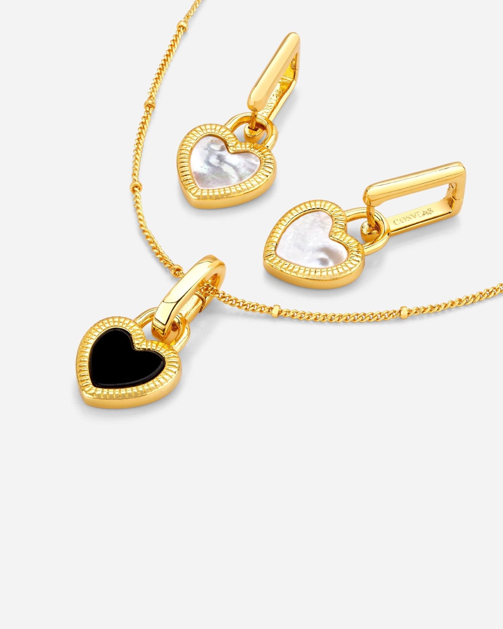 Detail des Reverie Duo Sets, 18k vergoldete Metalllegierung, Herzmotiv in Schwarz und Weiss, präzise verarbeitet