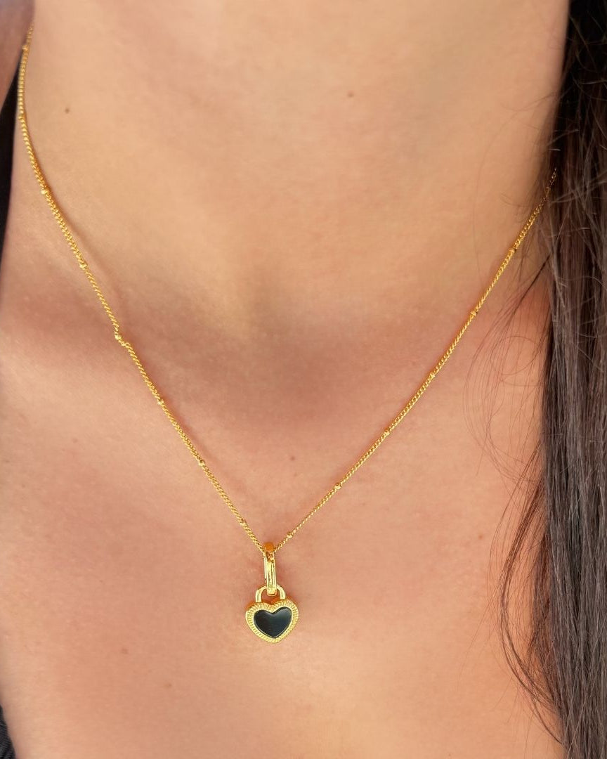 Reverie Halskette 18k vergoldet am Model getragen, wendbarer Herzanhänger, feiner Glanz, moderner Schmuck aus Zürich