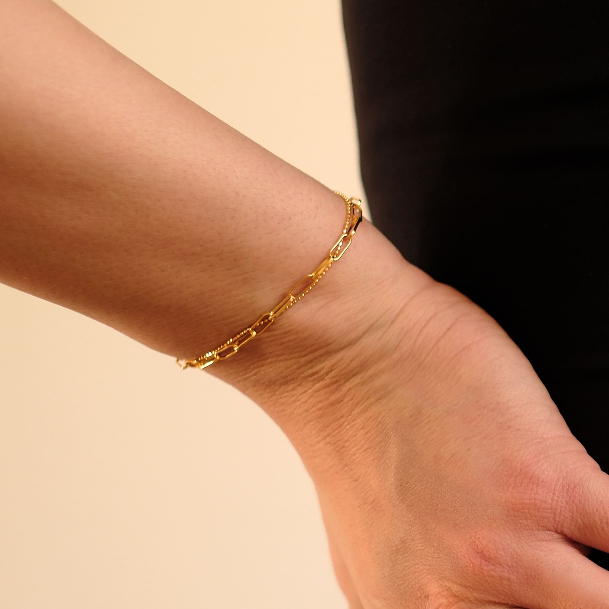 Model trägt das Cosytas Golden Duo Armband. Feines Armband mit zwei unterschiedlich gestalteten Goldketten für einen stilvollen, modernen Look. Ideal zum Kombinieren oder als dezenter Hingucker.