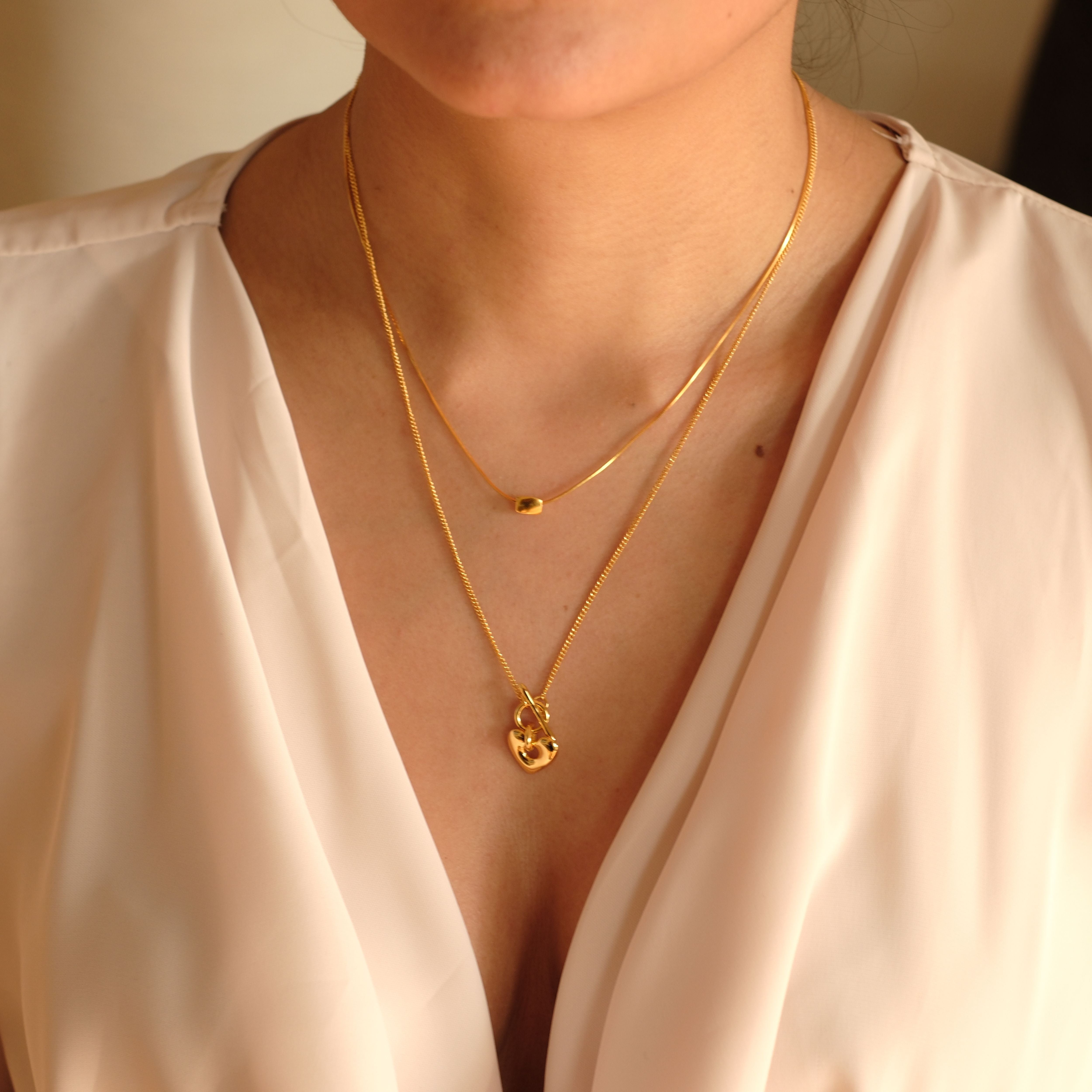 Cosytas doppellagige Halsketten mit filigranem Herzanhänger und minimalistischem Detail, gefertigt aus hochwertiger Metalllegierung mit 18k Gold-Veredelung. Dezentes und elegantes Schmuck-Layering für stilbewusste Looks.