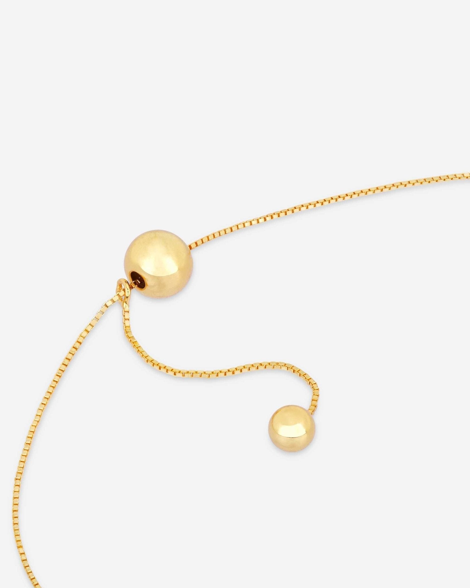 Detail der Golden Balance Halskette von Cosytas, Schmuckmarke aus Zürich, Y-Form mit polierten Kugeln, 18k vergoldet