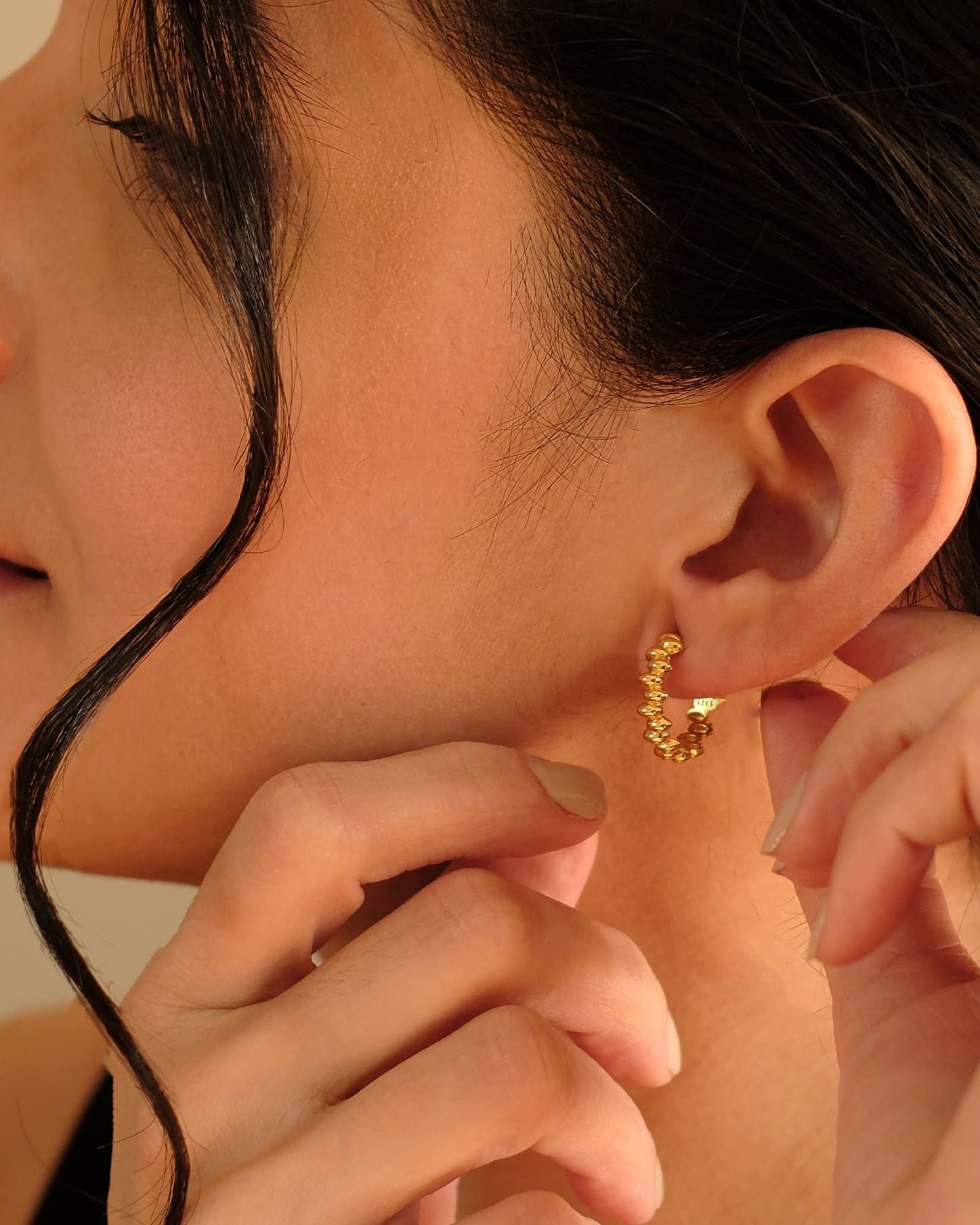 Golden Bead Hoops 18k vergoldet getragen am Ohr, zeitloser Ohrschmuck von Cosytas aus Zürich