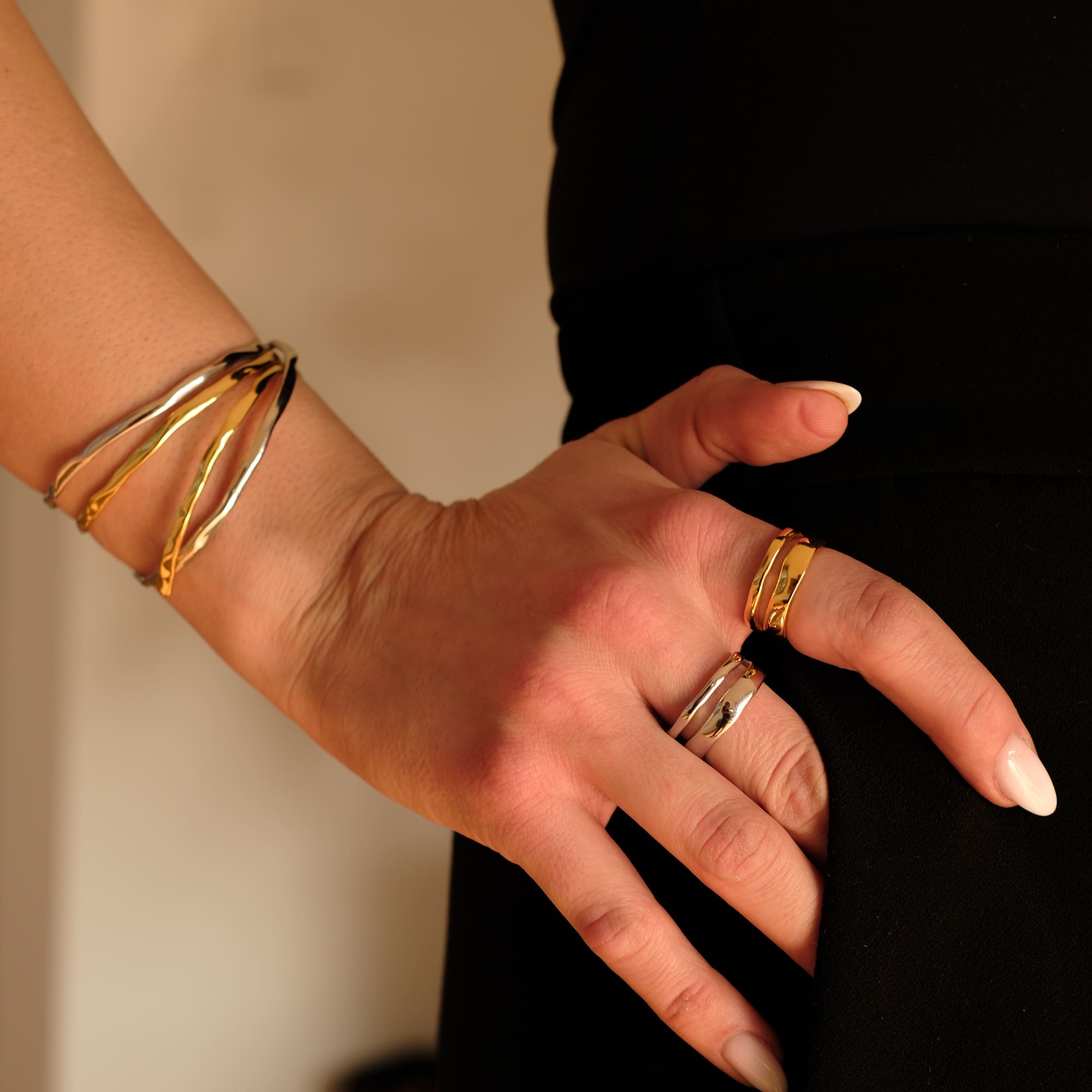 Nahaufnahme eines Handgelenks mit dem Cosytas Golden Flow Armband in Gold und Silber