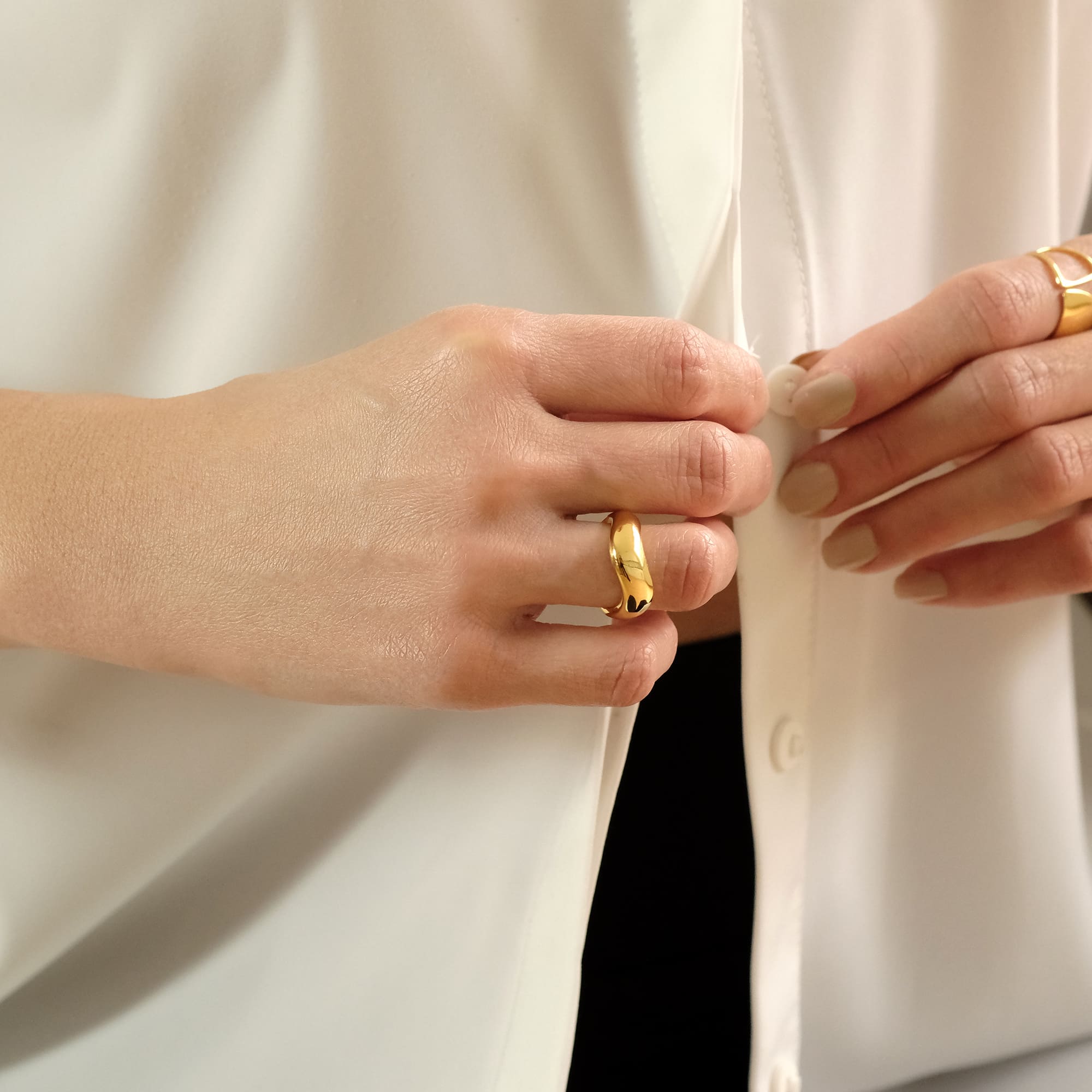 Hand mit dem Cosytas Golden Wave Ring aus 18k vergoldetem Sterling Silber
