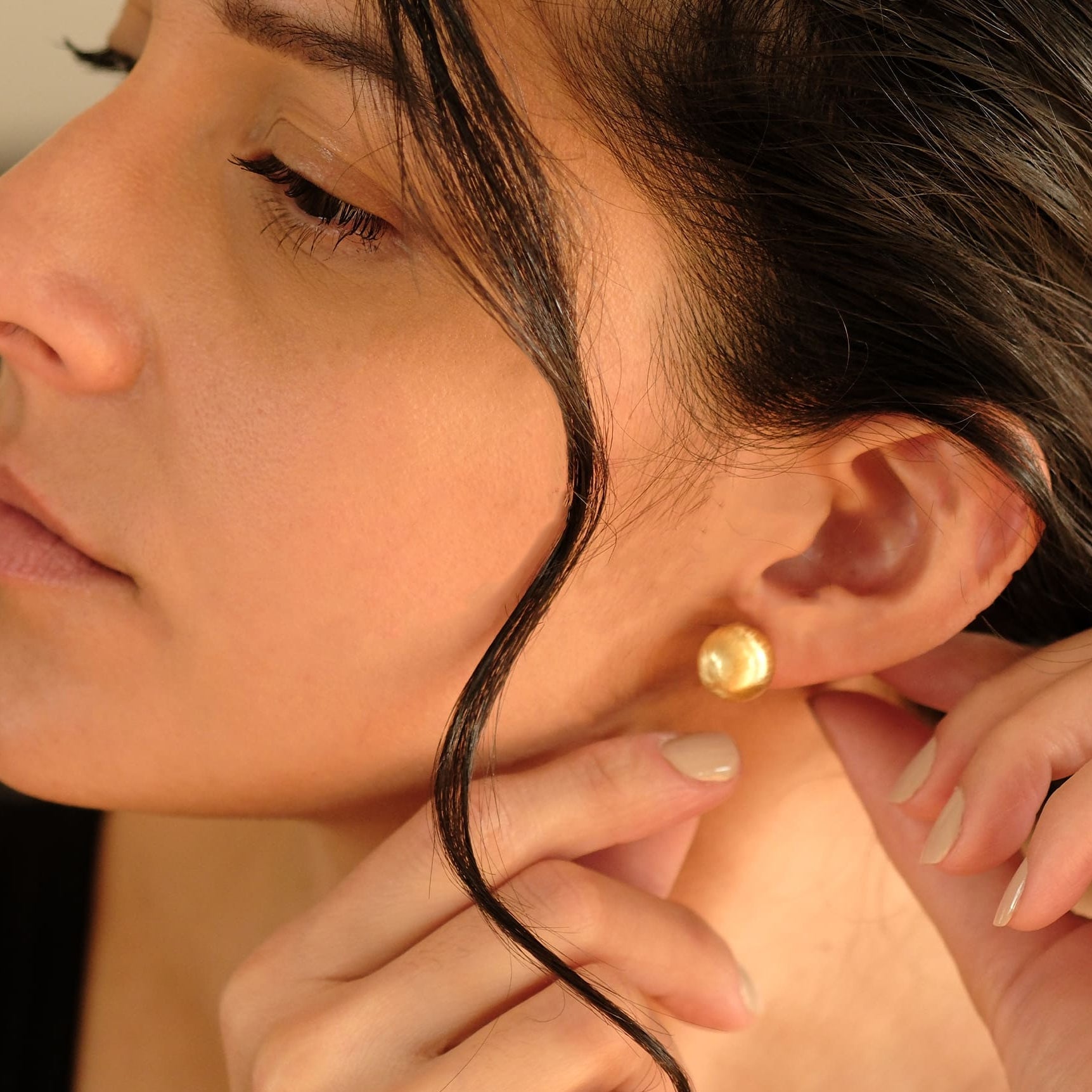 Nahaufnahme einer Frau mit den Cosytas Lumina Bold Gold Ohrringen