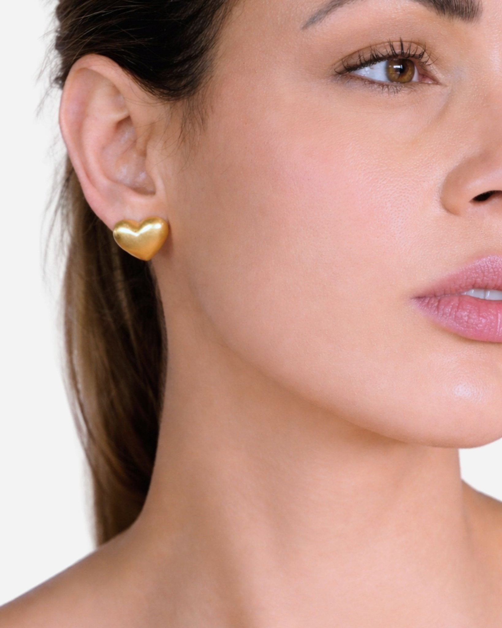 Lumina Gold Heart Ohrringe von Cosytas, Schmuckmarke aus Zürich, 18k vergoldete Herzform elegant am Ohr getragen