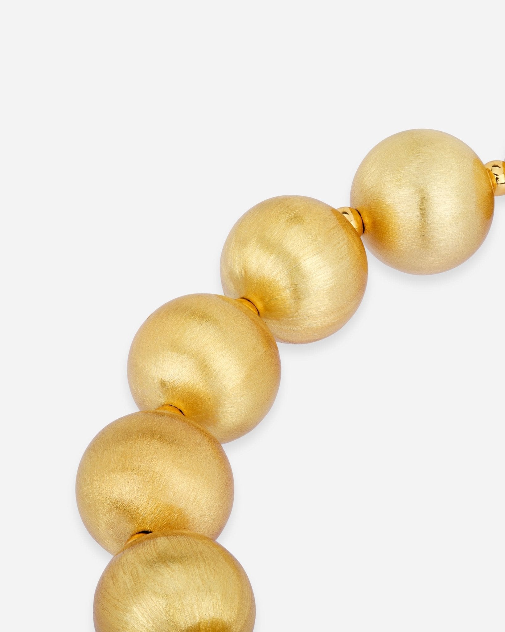 Detailaufnahme des Lumina Gold Sphere Armbands mit gleichmässig angeordneten, mattierten Goldkugeln.
