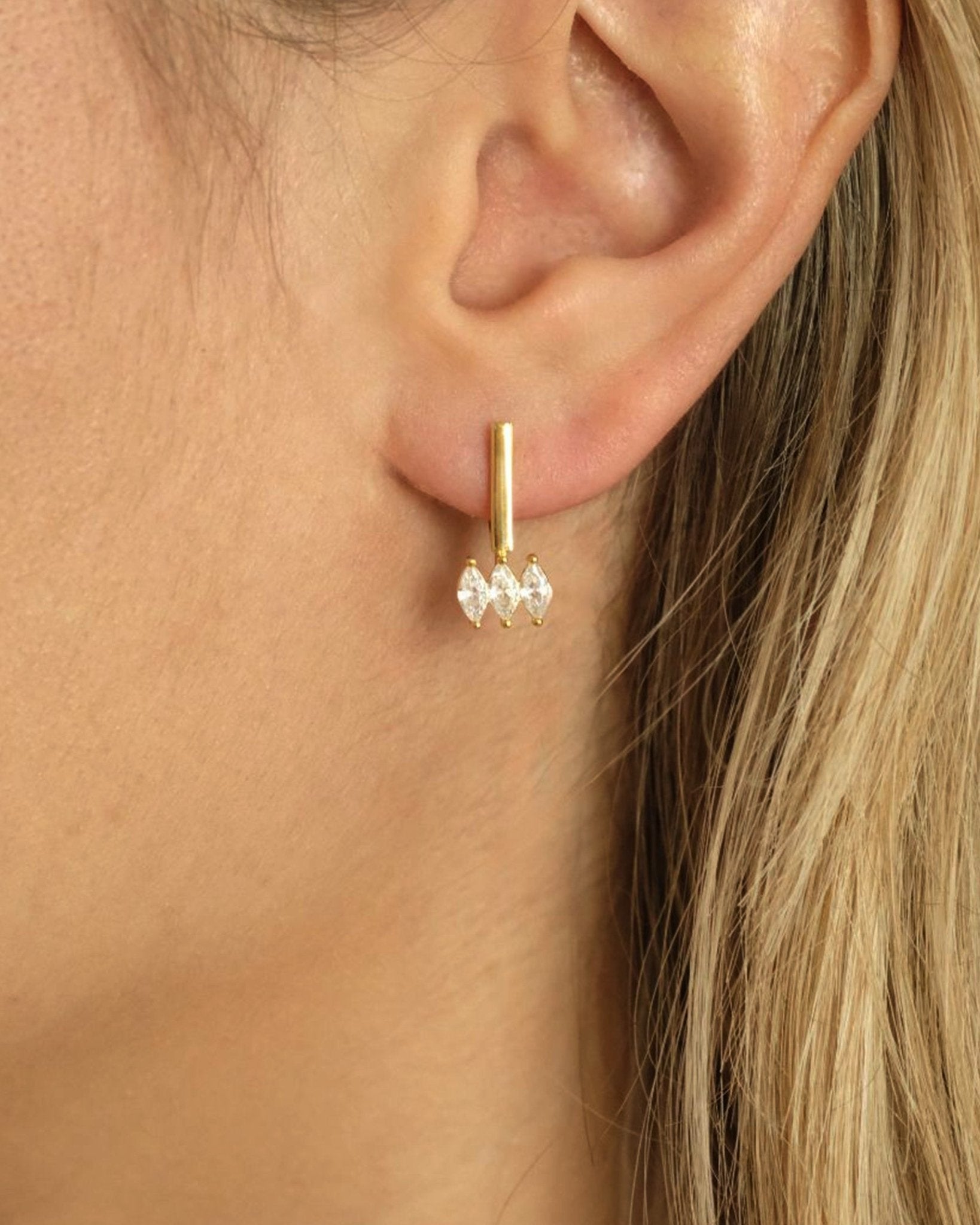 Nahaufnahme der Cosytas Moira White Ohrringe aus 18k Gold Vermeil auf 925 Silber mit funkelnden Zirkonia am Ohr
