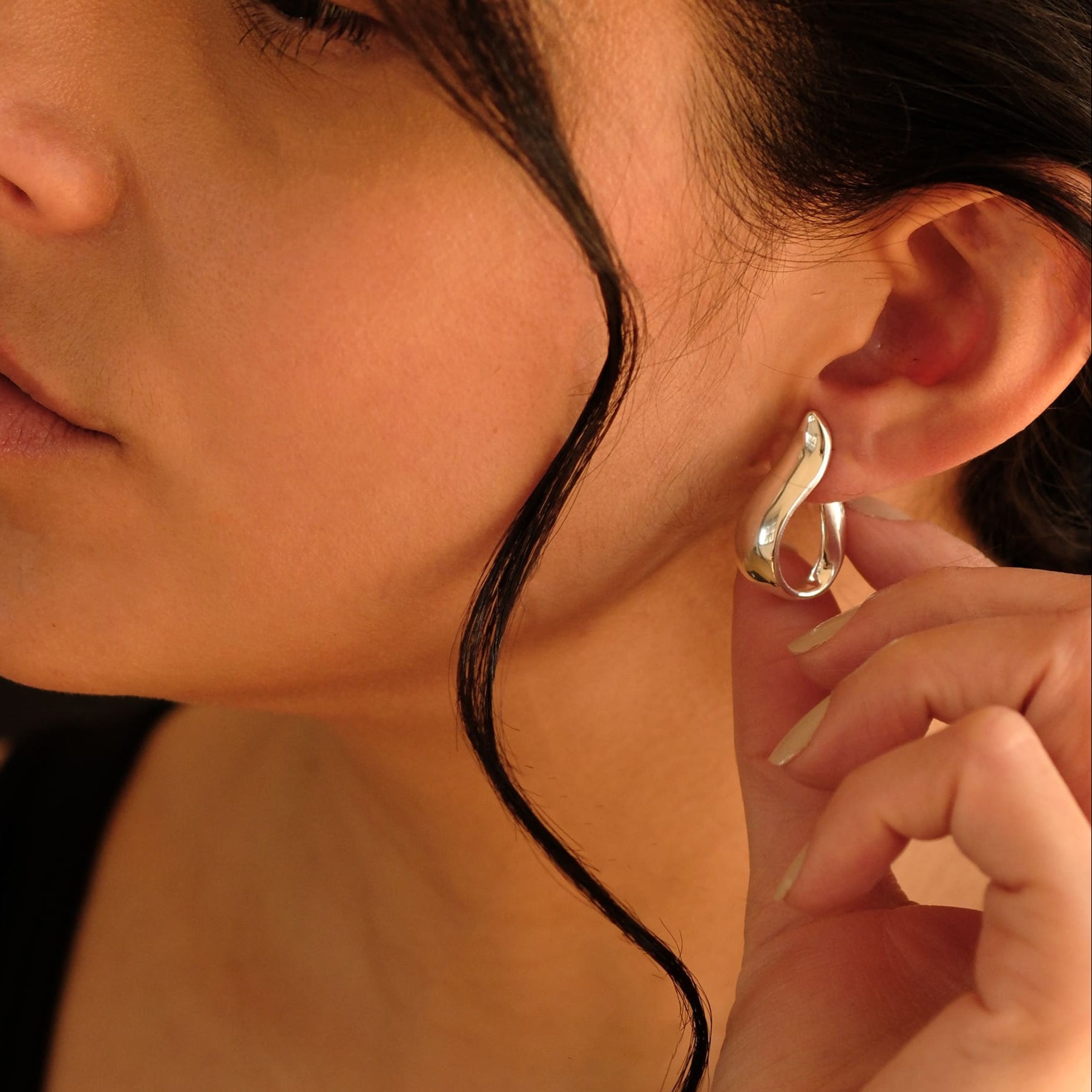 Nahaufnahme einer Frau mit den Cosytas Silver Wave Hoops